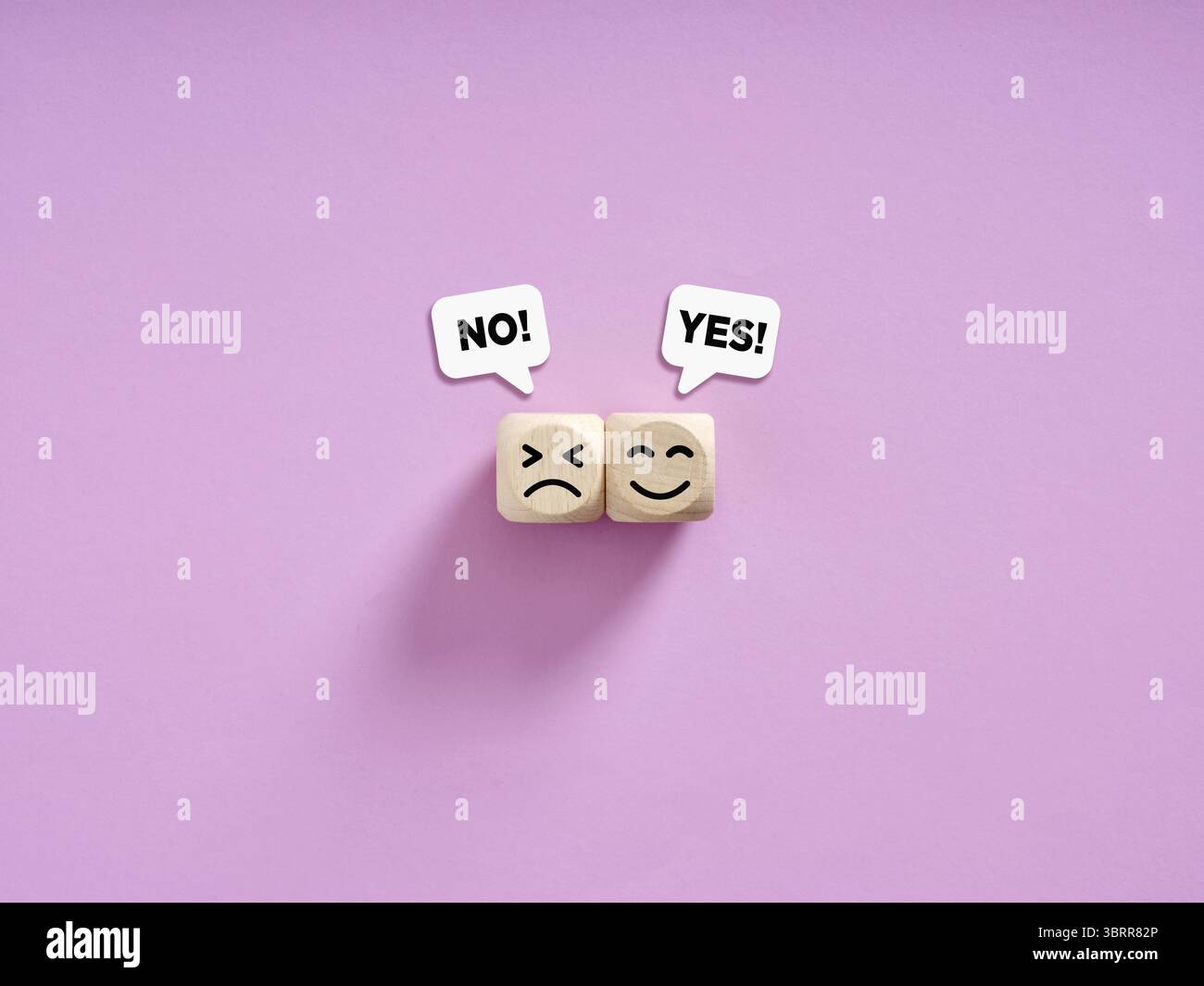 Due cubi di legno che mostrano un volto felice e triste con bolle di sì e no su sfondo viola che rappresentano un feedback positivo e negativo Foto Stock