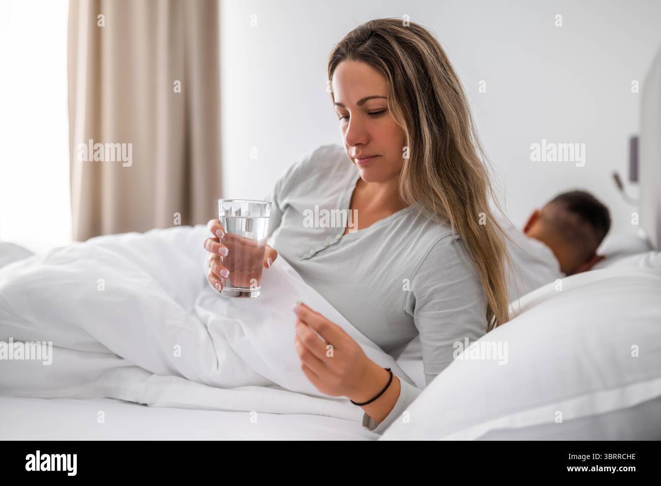 La donna non riesce a dormire. Sta prendendo pillole per dormire. Foto Stock