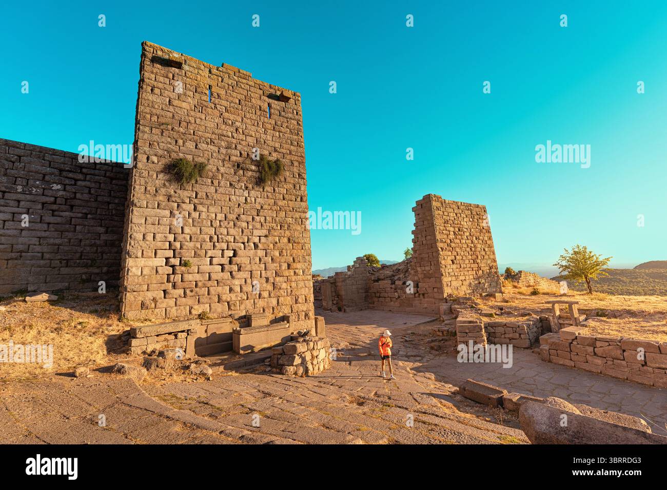 Turista che esplora le rovine di Assos, un'antica città greca situata nella moderna Behramkale, Turchia Foto Stock