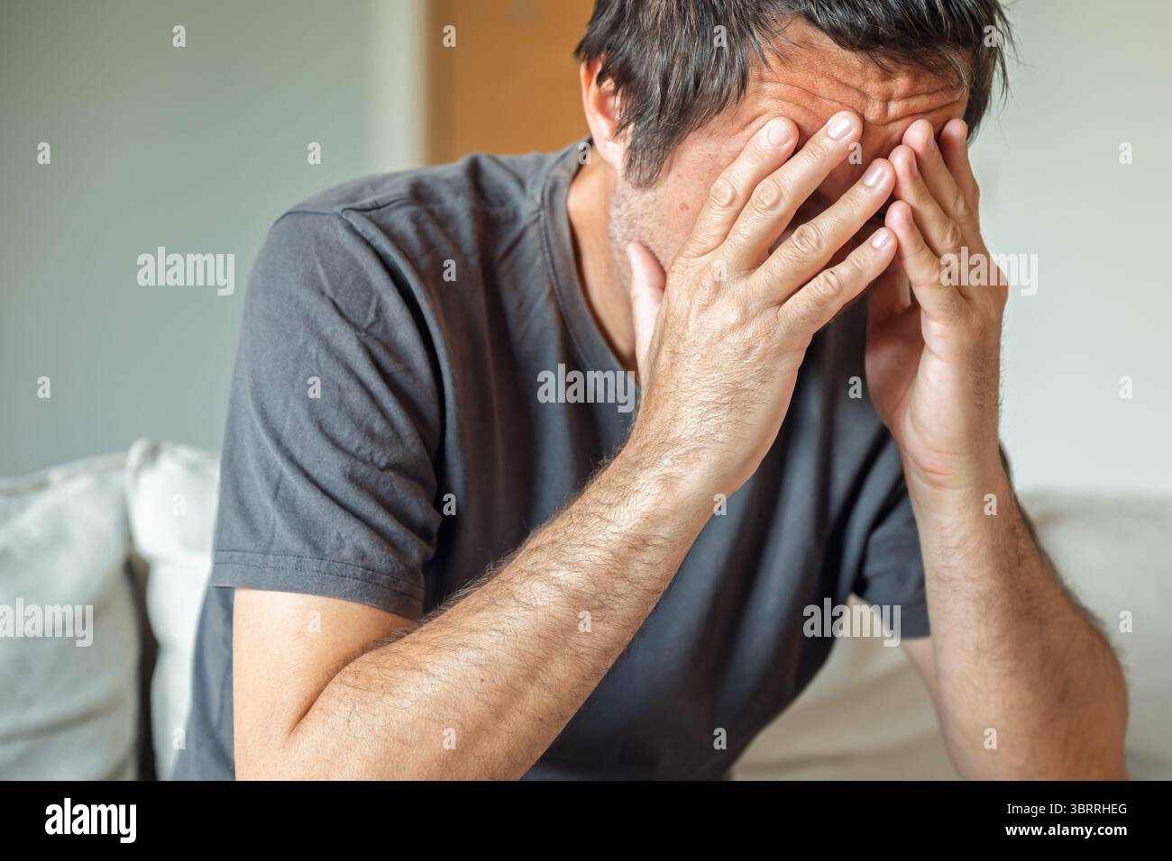 Concetto di disperazione, ritratto ravvicinato di un adulto maturo non rasato infelice e sconvolto, da solo a casa, focalizzazione selettiva Foto Stock