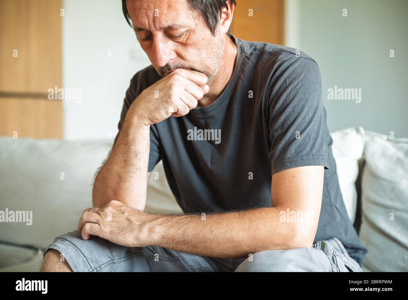 Concetto di disperazione, ritratto ravvicinato di un adulto maturo non rasato infelice e sconvolto, da solo a casa, focalizzazione selettiva Foto Stock