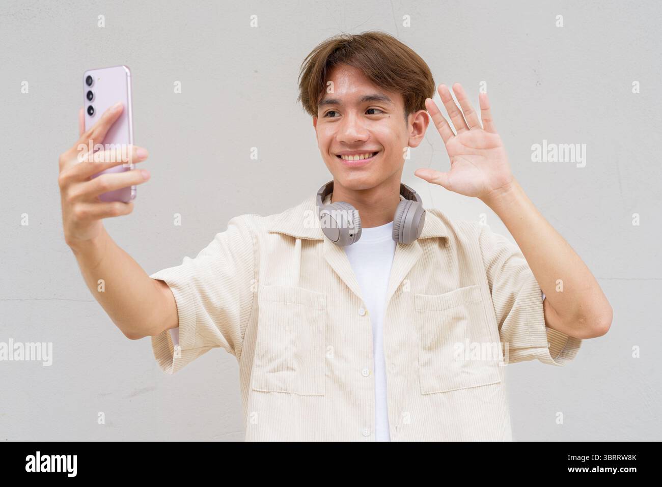 Non binario carino asiatico giovane gay uomo ritratto su sfondo semplice Foto Stock