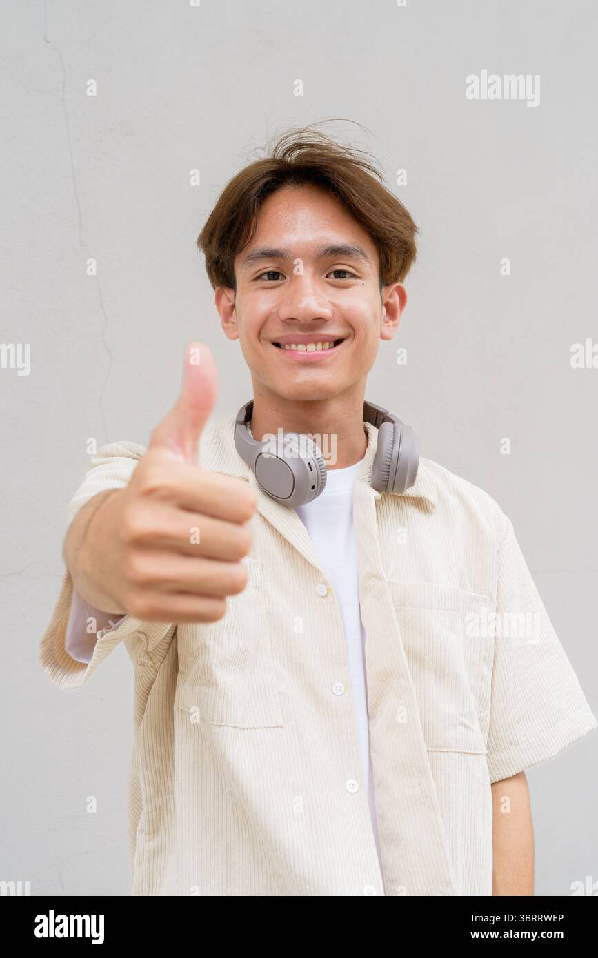 Non binario carino asiatico giovane gay uomo ritratto su sfondo semplice Foto Stock