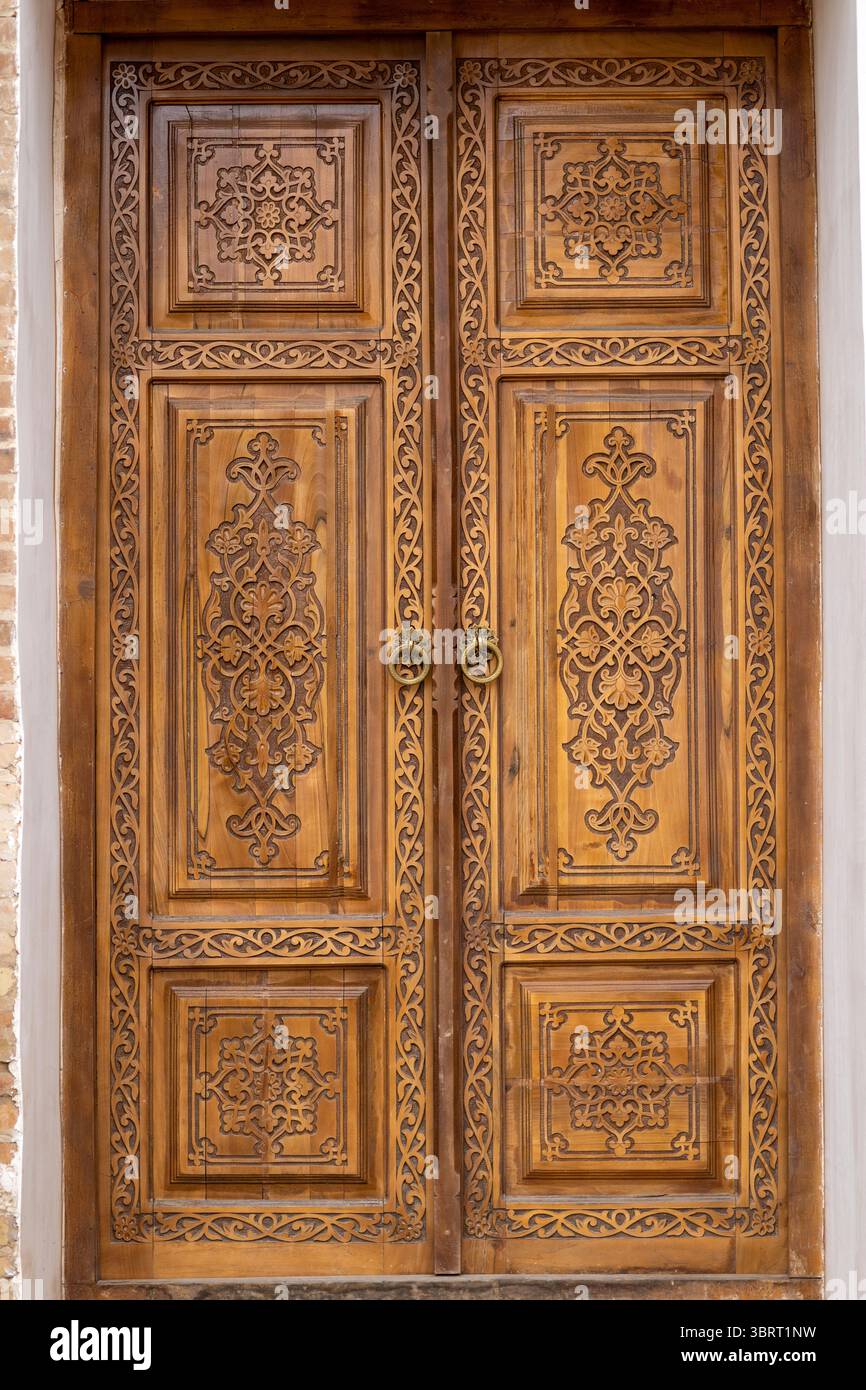 Porta in legno splendidamente intagliato in legno di noce, che mostra la tradizionale maestria artigianale e intricati motivi decorativi. Foto Stock