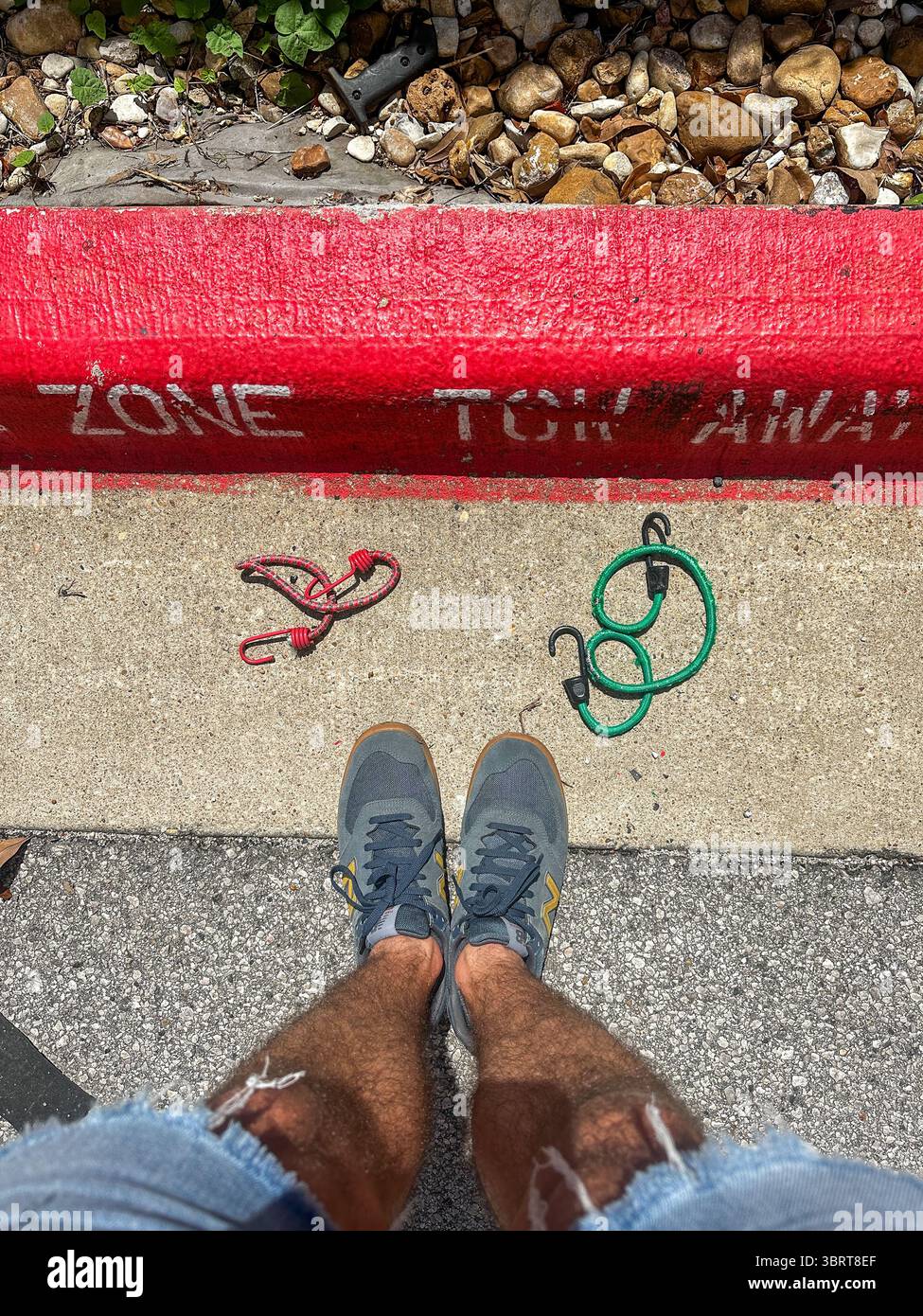 27 maggio 2025 - Austin, Texas, Stati Uniti - i marciapiedi dipinti rossi di una zona di traino senza parcheggio su una superstrada, in piena luce del sole. Foto Stock