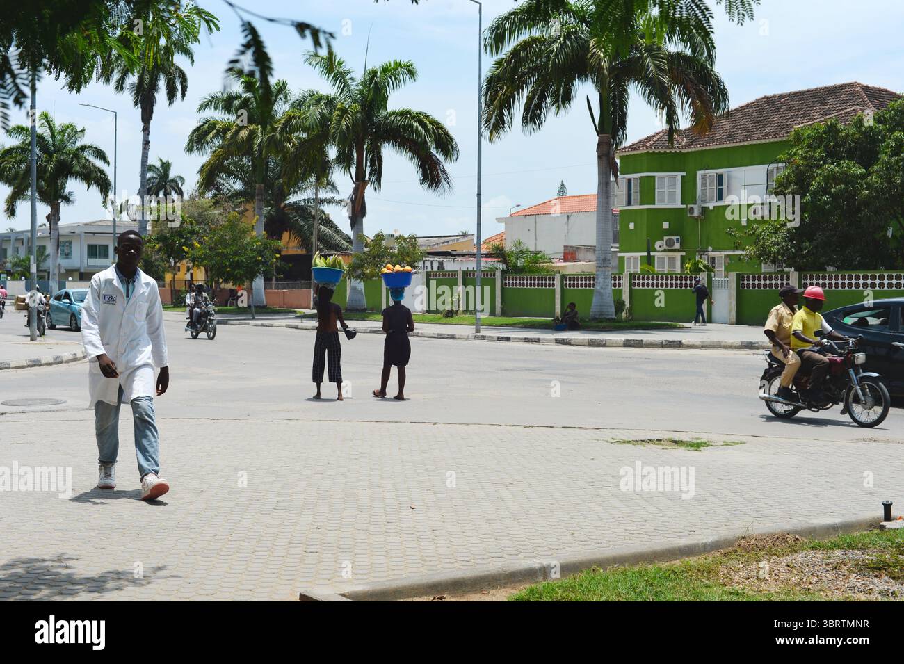 BENGUELA, ANGOLA - 13 febbraio 2025: Persone che camminano per la strada di Benguela. Donne che vendono frutta per strada. Foto Stock