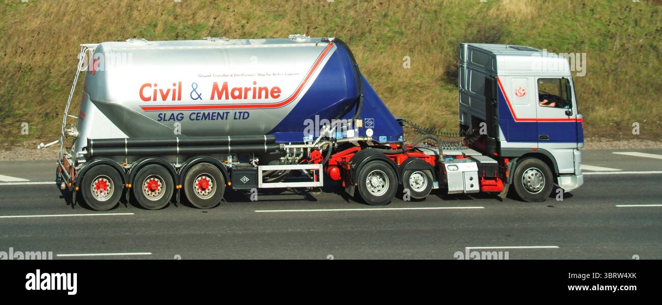 Il logo commerciale Civil & Marine Slag Cement, associato anche a Slag Cement Ltd. Visto in un archivio storico una vista laterale di un autocarro autocisterna articolato per autocarri hgv un veicolo commerciale con assale a pneumatici rialzati Economy con conducente al lavoro che guida lungo la strada autostradale M25 e il percorso orbitale di Londra sulla sezione Essex tra gli svincoli 27 e 28 in Inghilterra Regno Unito Foto Stock