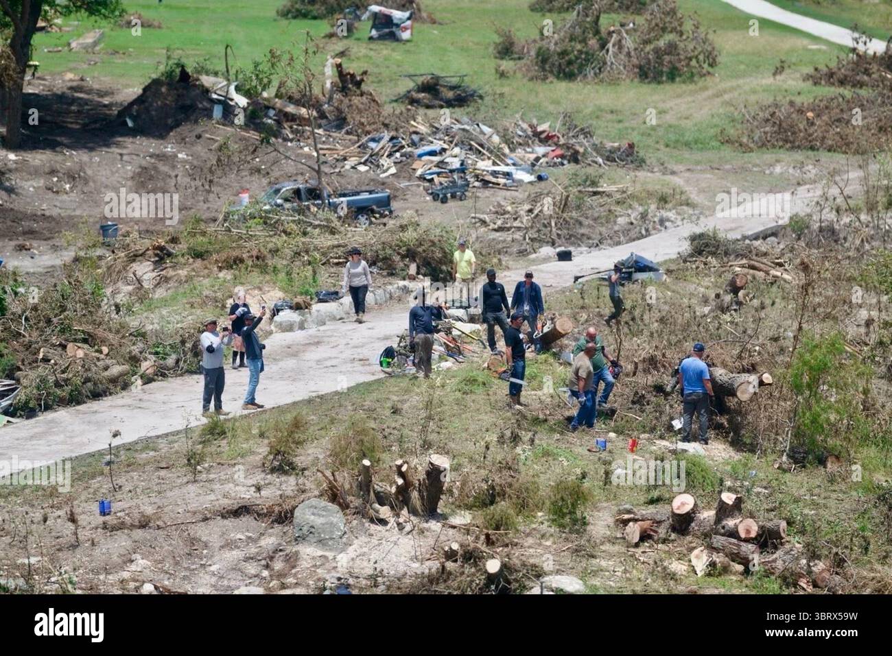 Volontari e membri della comunità assistono con gli sforzi di pulizia dopo una grave inondazione a Kerrville, Texas, l'11 luglio 2025. Alberi caduti, detriti e proprietà danneggiate sono visibili in tutta l'area. Per gentile concessione della Casa Bianca. Foto Stock Volontari e membri della comunità assistono con gli sforzi di pulizia dopo una grave inondazione a Kerrville, Texas, l'11 luglio 2025. Alberi caduti, detriti e proprietà danneggiate sono visibili in tutta l'area. Per gentile concessione della Casa Bianca. Foto Stock