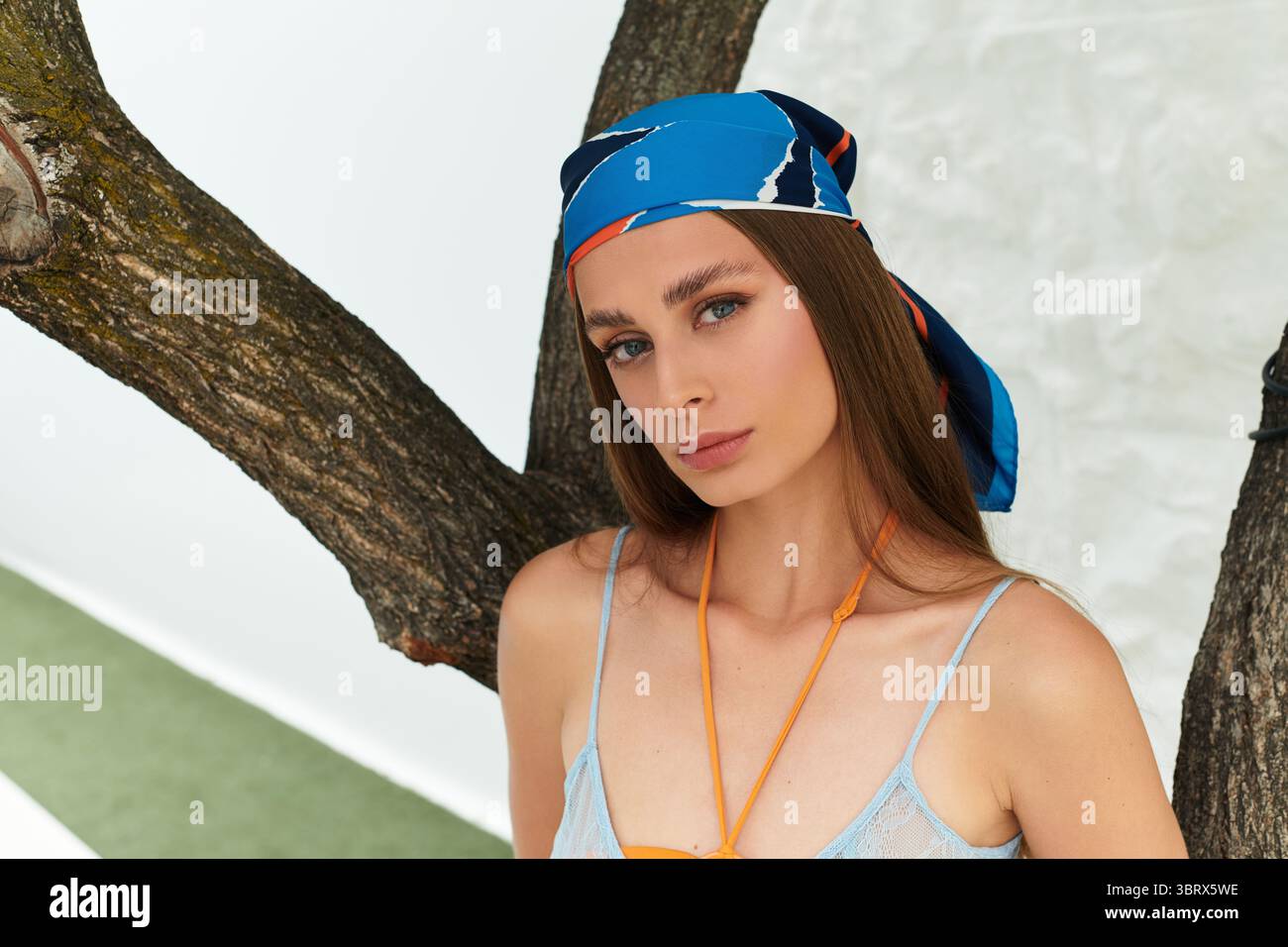 Una giovane donna gode dell'atmosfera estiva, mostrando la sua bellezza con un elegante velo. Foto Stock