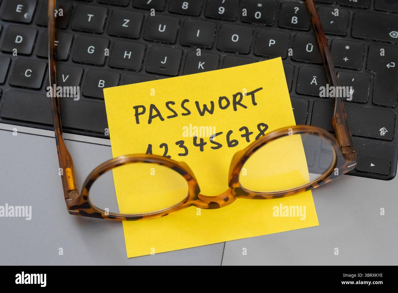 Rischio per la sicurezza sulla scrivania: Un foglio di carta con la password non sicura 12345678 aperta su un laptop Foto Stock Rischio per la sicurezza sulla scrivania: Un foglio di carta con la password non sicura 12345678 aperta su un laptop Foto Stock