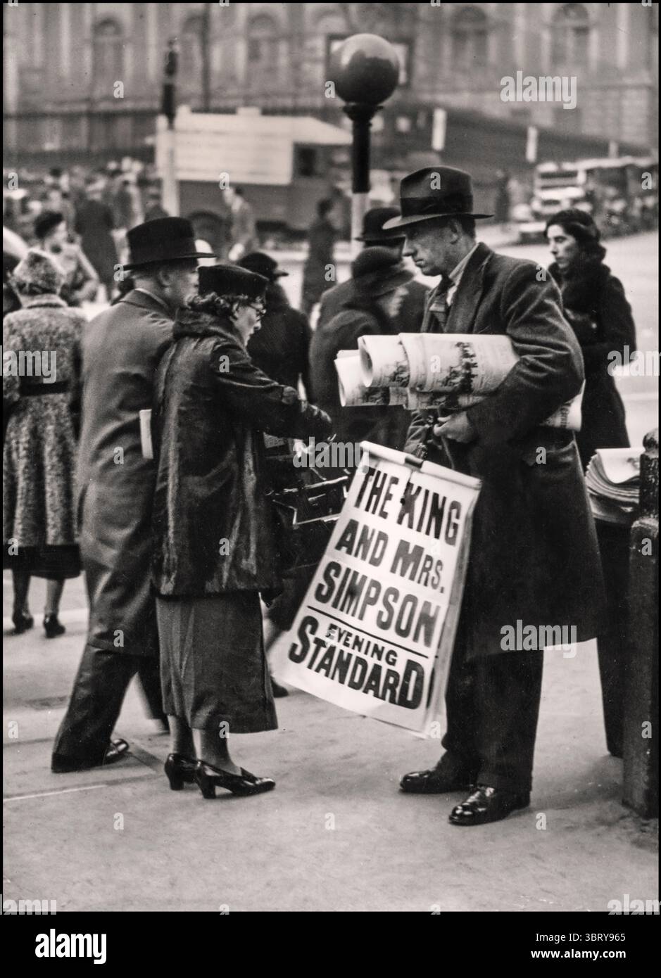 Venditore di notizie ABDICAZIONE che vende copie del quotidiano Evening Standard con il titolo "IL RE E LA SIGNORA. SIMPSON' questo si riferisce alla relazione molto pubblicizzata tra re Edoardo VIII e il socialite americano Wallis Simpson, che portò ad una crisi costituzionale e all'abdicazione di Edoardo dal trono britannico nel 1936 re Edoardo VIII, che salì al trono nel gennaio 1936, si innamorò di Wallis Simpson, una donna americana divorziata due volte. Di fronte alla scelta tra la corona e il suo amore, Edoardo scelse di abdicare nel dicembre 1936 e successivamente sposò Wallis Simpson in Francia nel 1937 Foto Stock