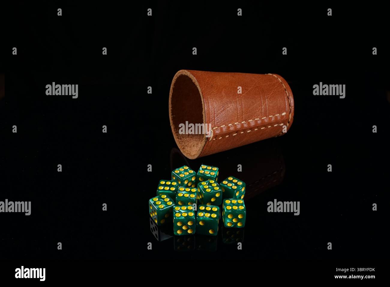 Tazza di cuoio con 6 dadi verdi Foto Stock