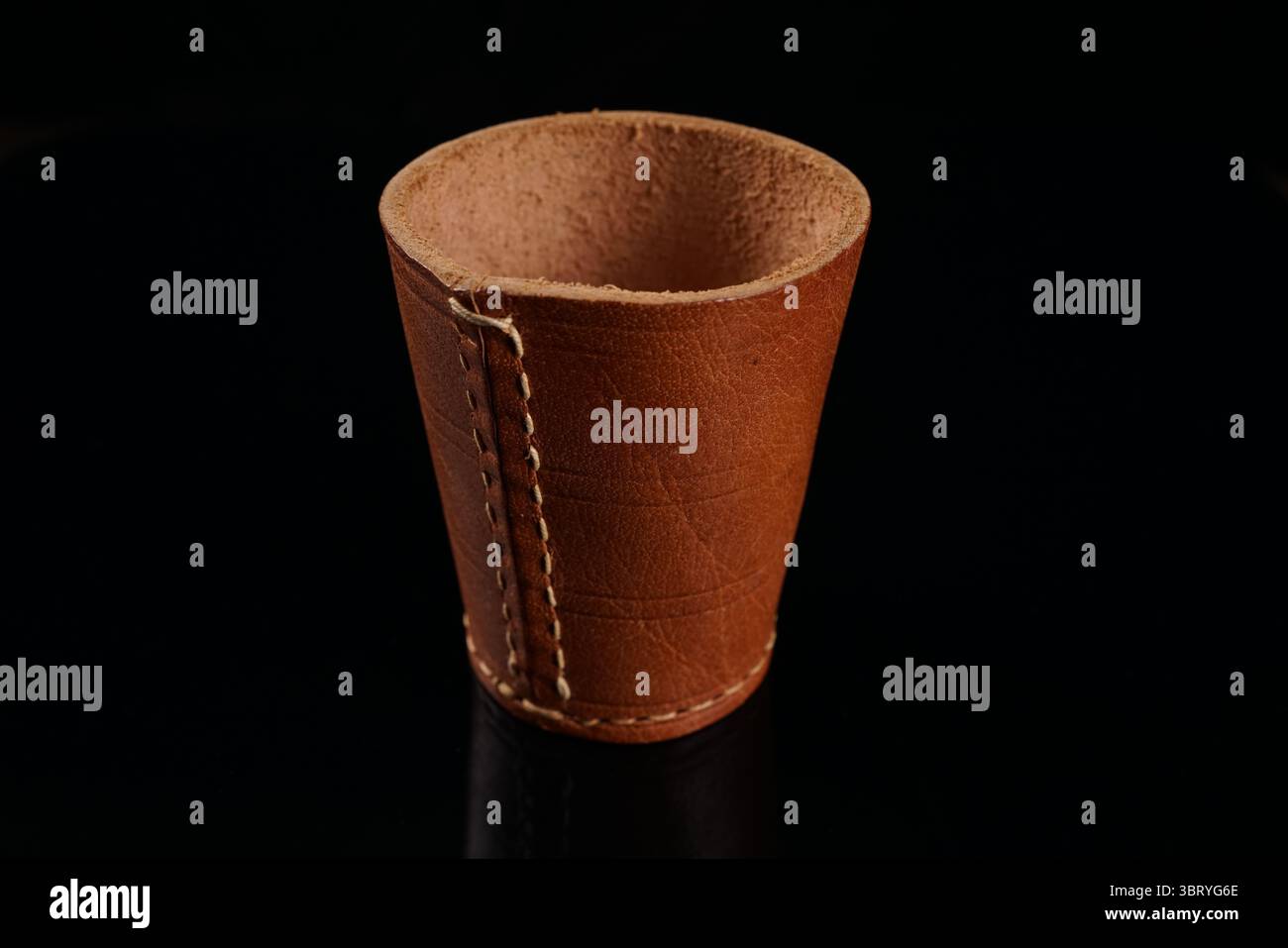 Tazza a dadi in pelle con sfondo nero Foto Stock