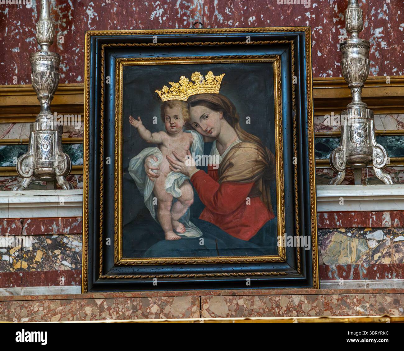 Una piccola tela incorniciata raffigurante la Madonna col bambino con corone dorate in rilievo. L'opera si trova nella Cattedrale di Santa Maria Assunta. Fermo, Marche Foto Stock