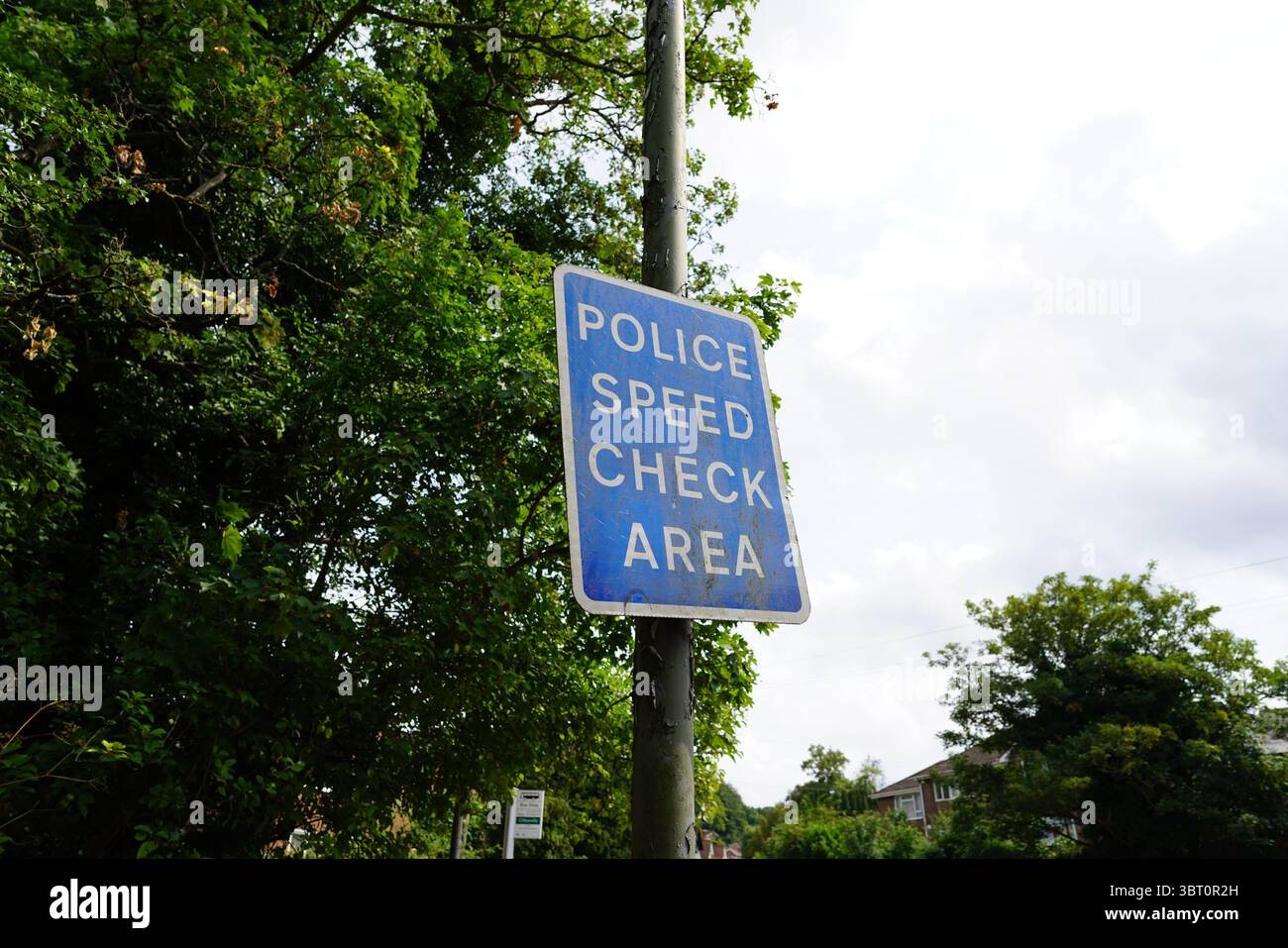 Cartello dell'area di controllo della velocità della polizia contro Green Foliage e Cloudy Sky. Dorking, Inghilterra Foto Stock