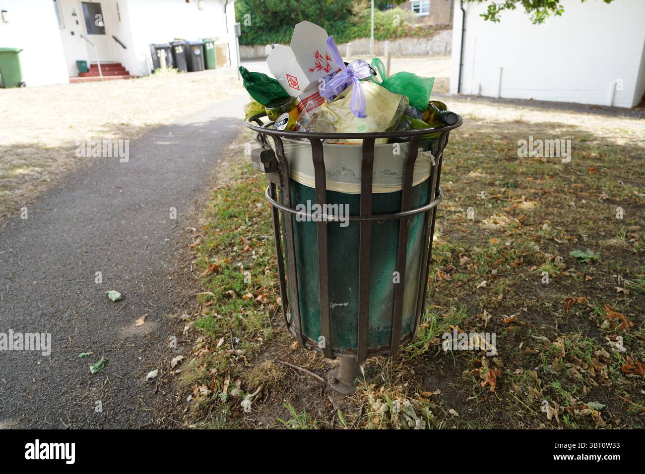 Traboccante di rifiuti in un parco all'aperto in una giornata di sole. Dorking, Inghilterra Foto Stock