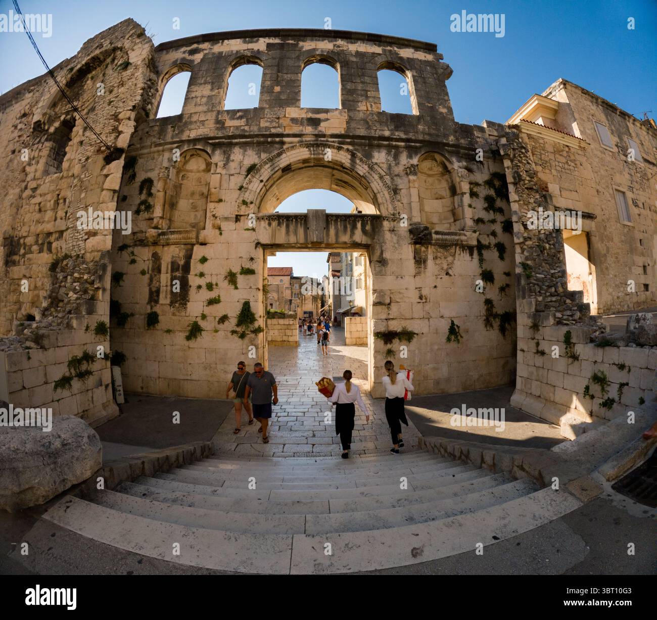 Spalato, Croazia - 8 settembre 2023: Le persone camminano attraverso l'antico Palazzo di Diocleziano, un sito patrimonio dell'umanità dell'UNESCO, esplorando la storica arcite Foto Stock