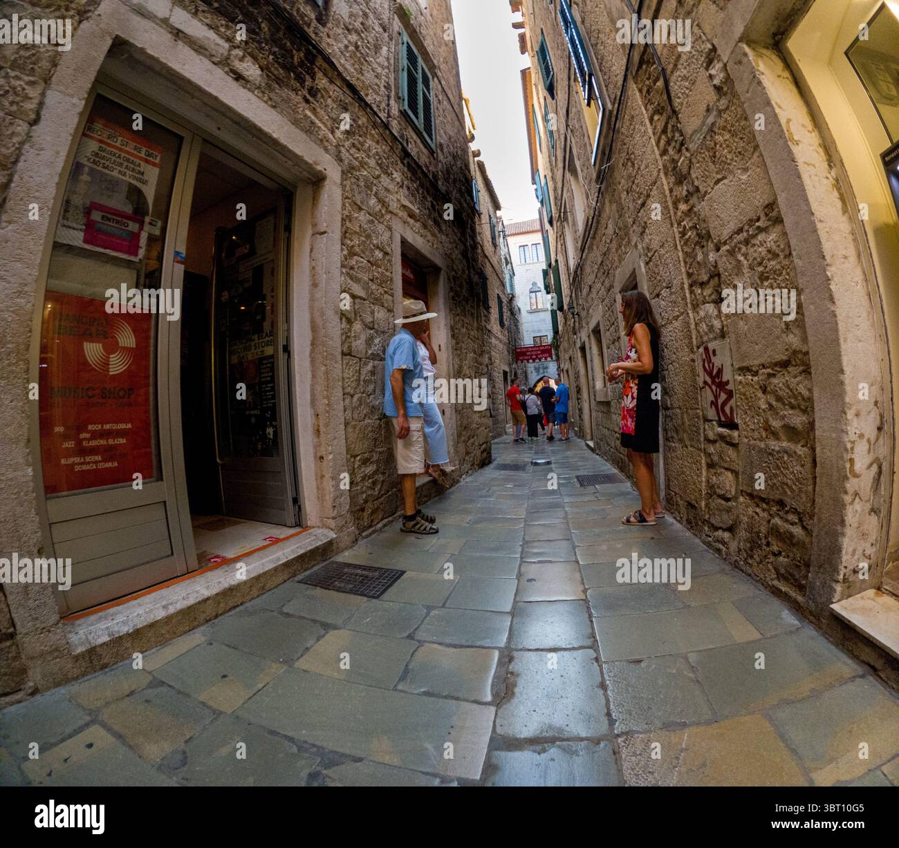 Spalato, Croazia - 8 settembre 2023: I turisti esplorano una strada stretta vicino a un negozio di musica e al Museo della città di Spalato, godendosi l'histo della città Foto Stock