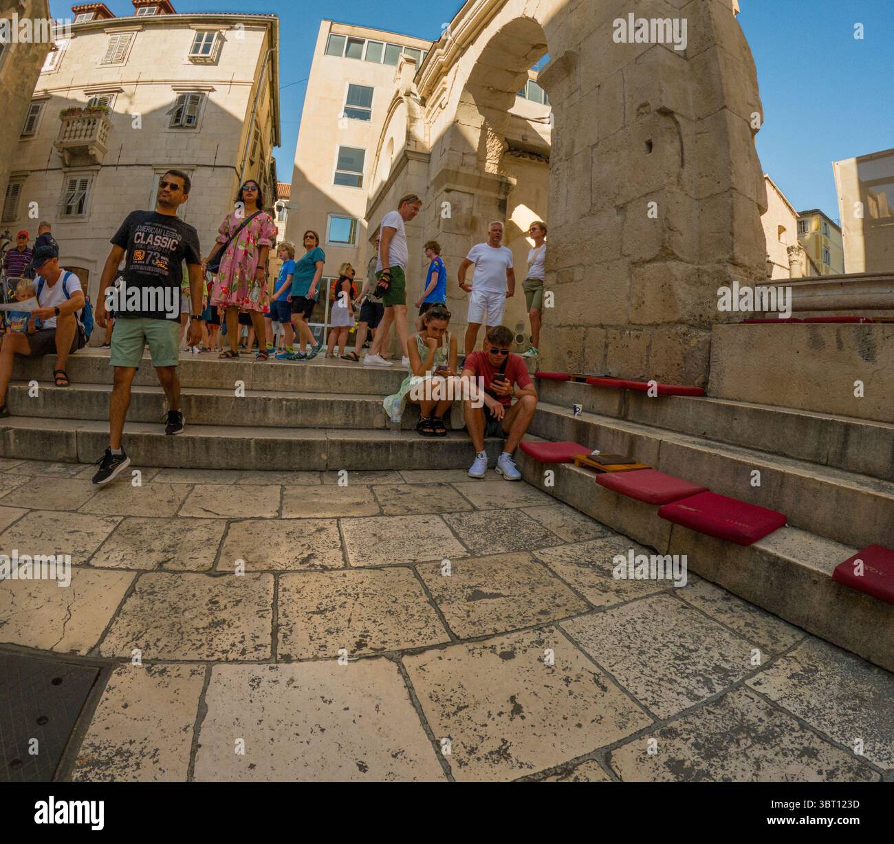 Spalato, Croazia - 8 settembre 2023: I turisti esplorano il Palazzo di Diocleziano, patrimonio dell'umanità dell'UNESCO. Alcuni camminano, mentre altri si rilassano sul Foto Stock