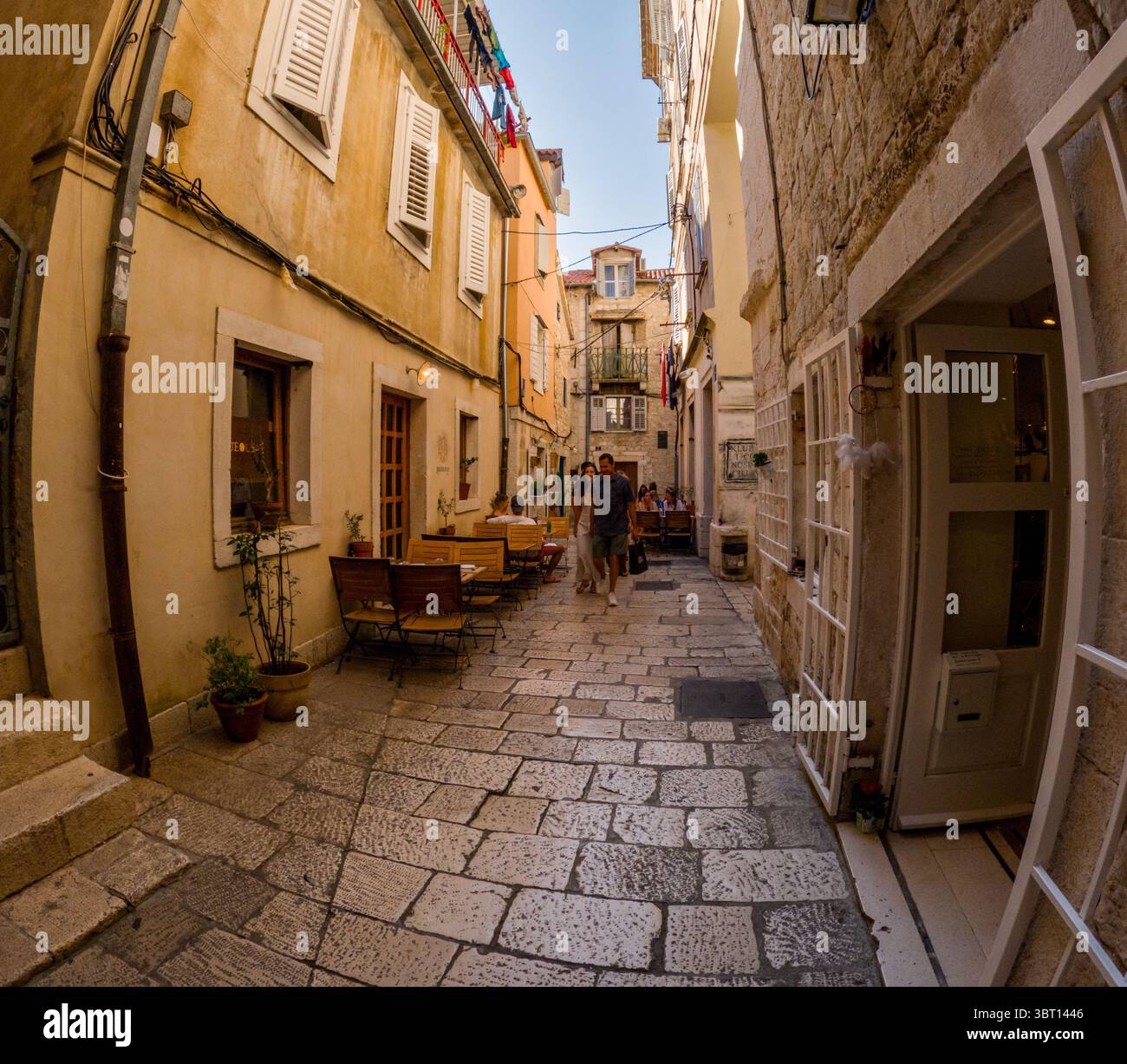Spalato, Croazia - 8 settembre 2023: Un paio di passeggiate lungo una strada stretta costeggiata da ristoranti, godendosi l'atmosfera e la cultura locale. Foto Stock
