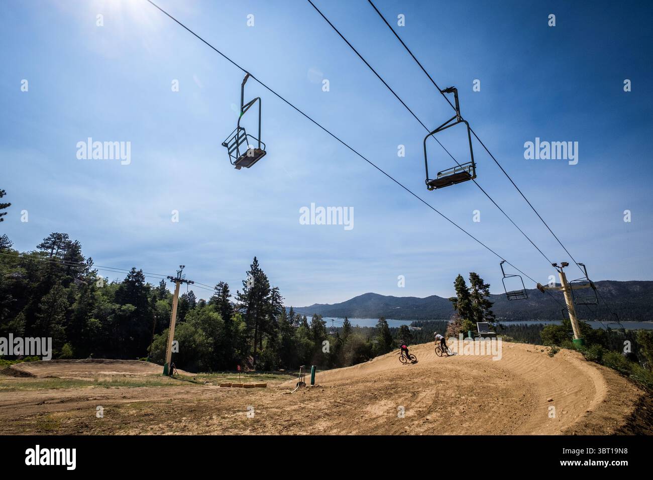 Gli amanti della discesa in mountain bike scendono su un sentiero ormeggiato per MTB presso la stazione sciistica di Snow Summit a Big Bear Lake, California, Stati Uniti. Foto Stock