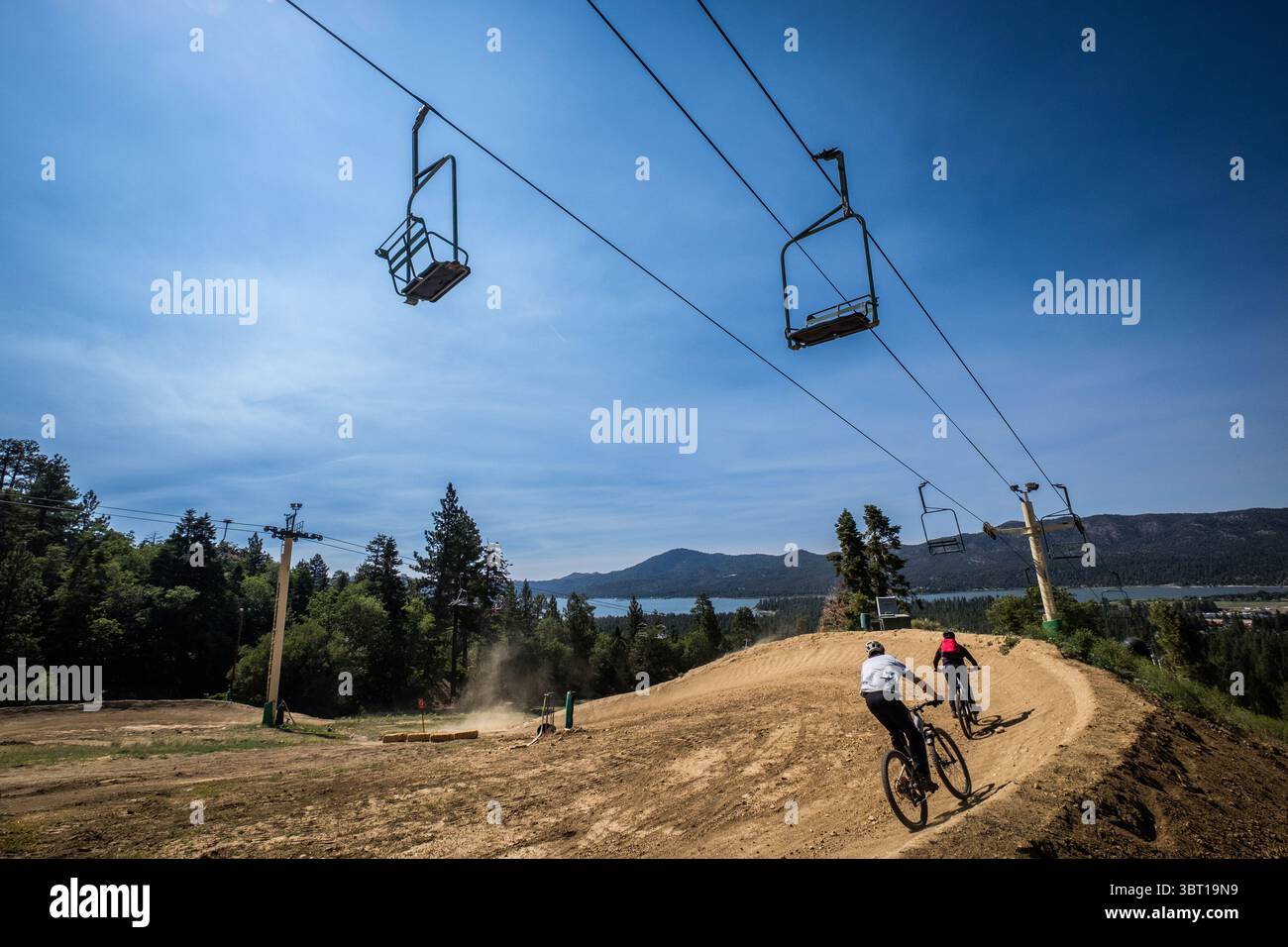 Gli amanti della discesa in mountain bike scendono su un sentiero ormeggiato per MTB presso la stazione sciistica di Snow Summit a Big Bear Lake, California, Stati Uniti. Foto Stock