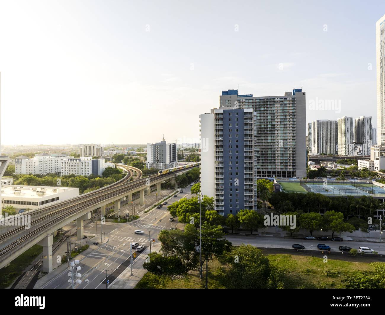 Vista aerea dei binari sopraelevati che attraversano il vivace paesaggio urbano, dove gli edifici raggiungono il cielo sullo sfondo di un orizzonte soleggiato, Miami, Florida, Stati Uniti. Foto Stock