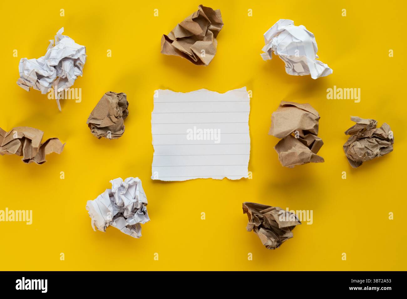 Spianatura artistica di palle di carta increspate intorno a un pezzo di carta bianco , sfondo creativo del processo Foto Stock