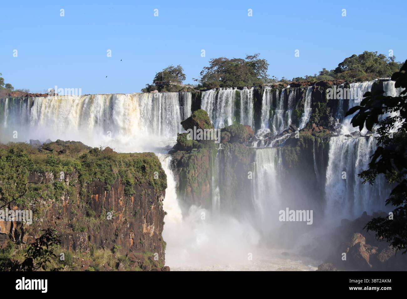 Vista panoramica delle potenti Cascate dell'Iguazú nel Parco Nazionale dell'Iguazú, in Argentina, in una giornata di sole. Enormi cascate d'acqua. Meraviglia naturale. Foto Stock