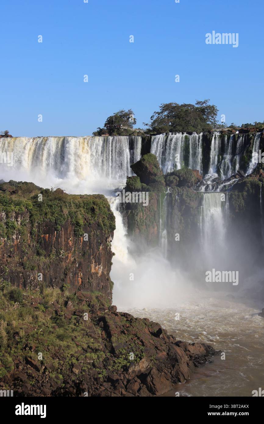 Vista panoramica delle potenti Cascate dell'Iguazú nel Parco Nazionale dell'Iguazú, in Argentina, in una giornata di sole. Enormi cascate d'acqua. Meraviglia naturale. Foto Stock