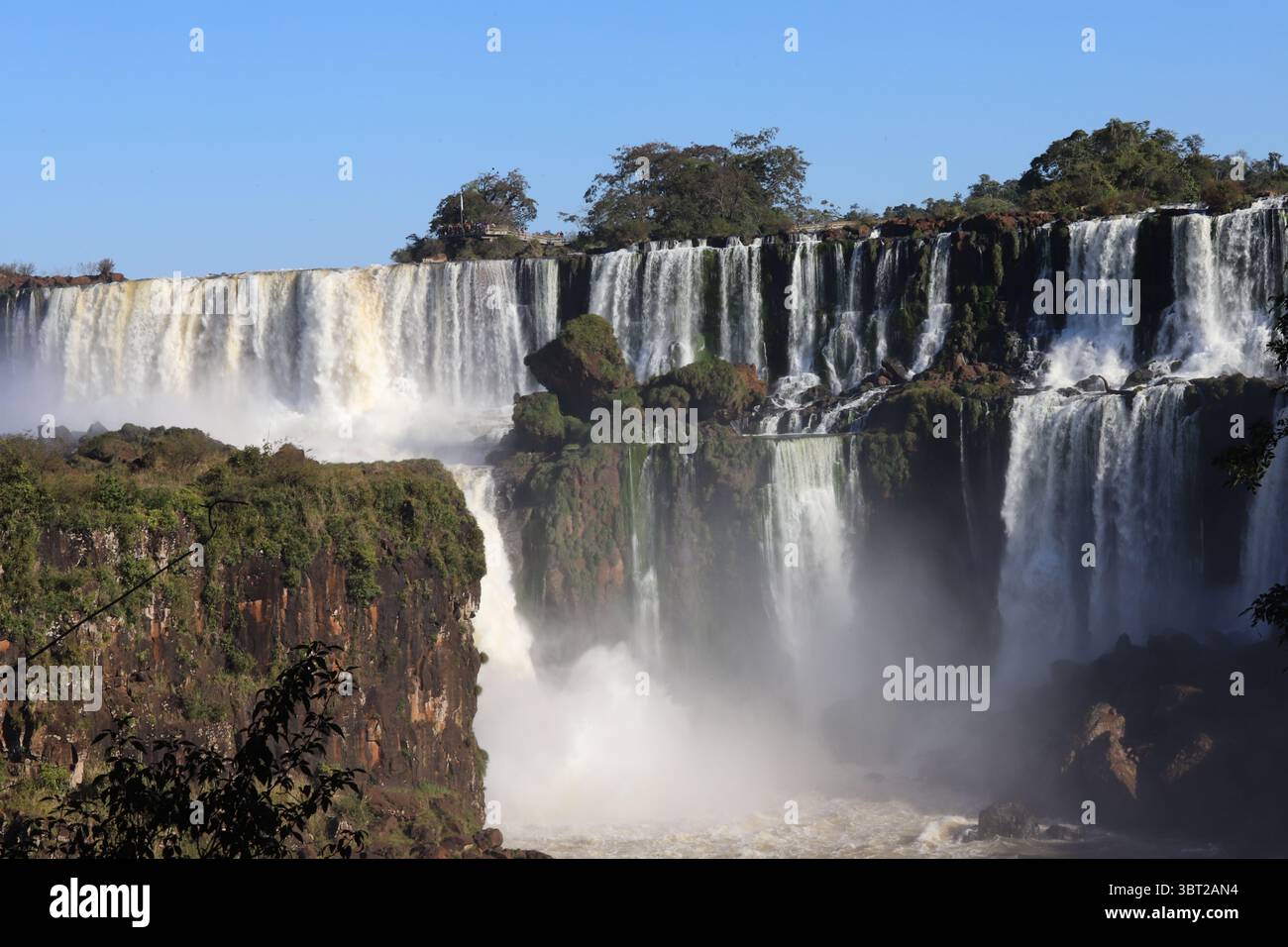 Vista panoramica delle potenti Cascate dell'Iguazú nel Parco Nazionale dell'Iguazú, in Argentina, in una giornata di sole. Enormi cascate d'acqua. Meraviglia naturale. Foto Stock