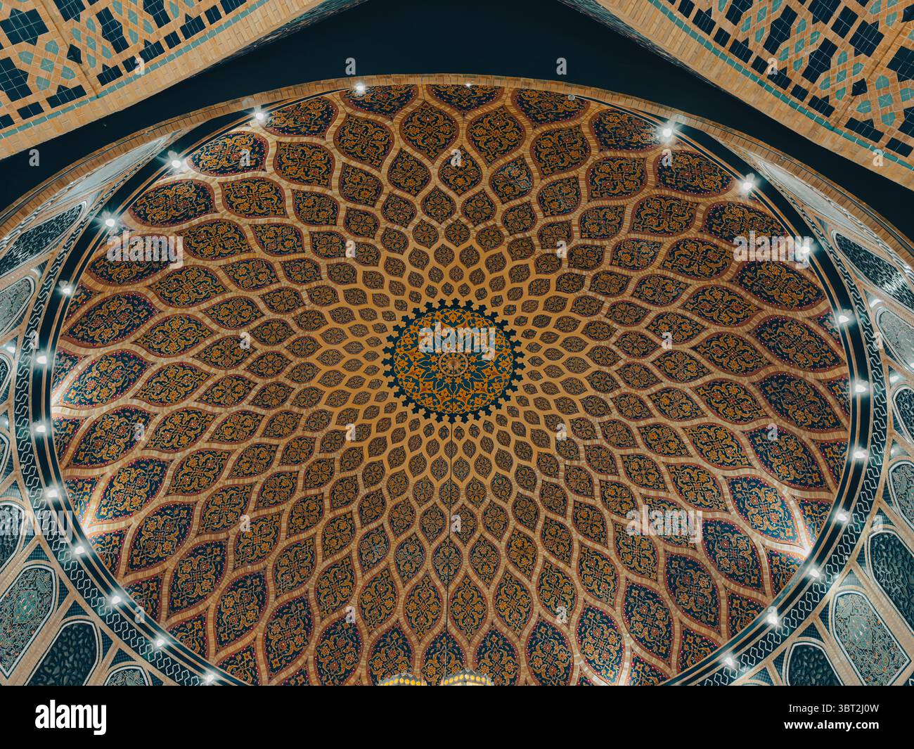 Eleganti motivi blu e oro all'interno della moschea islamica con cupola e archi Foto Stock
