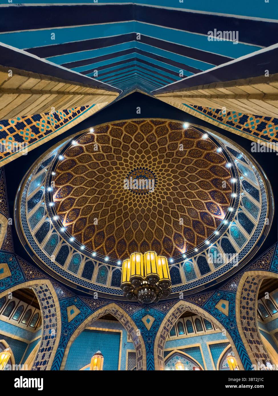 Eleganti motivi blu e oro all'interno della moschea islamica con cupola e archi Foto Stock