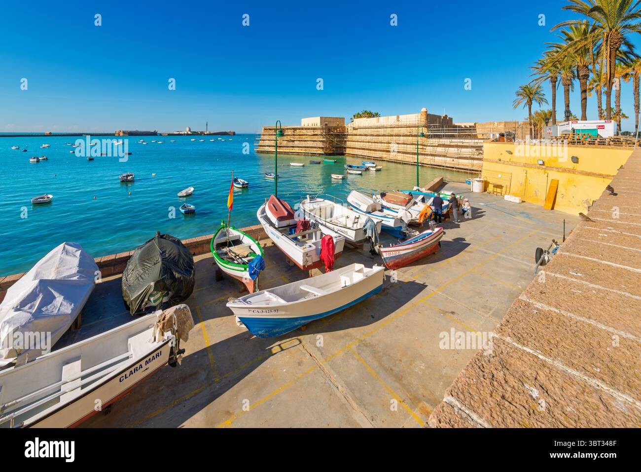 Vista dalla spiaggia di la Caleta e dal porticciolo delle barche della fortezza Castillo de Santa Catalina del XVII secolo a Cadice, Spagna. Foto Stock