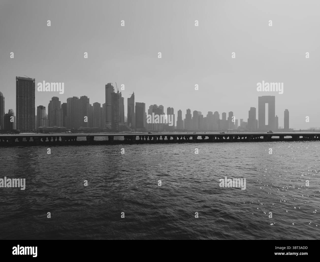 Vista cinematografica dello skyline di Dubai Marina al tramonto, sfondo immobiliare bianco e nero Foto Stock