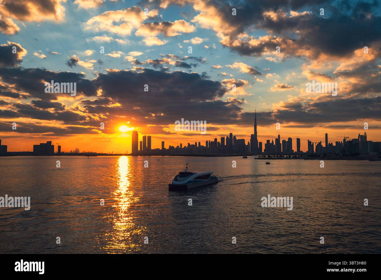 Tramonto epico sullo sfondo dello skyline della città, con una barca in primo piano e uno skyline della città stagliato contro un cielo colorato pieno di nuvole, soffice Foto Stock