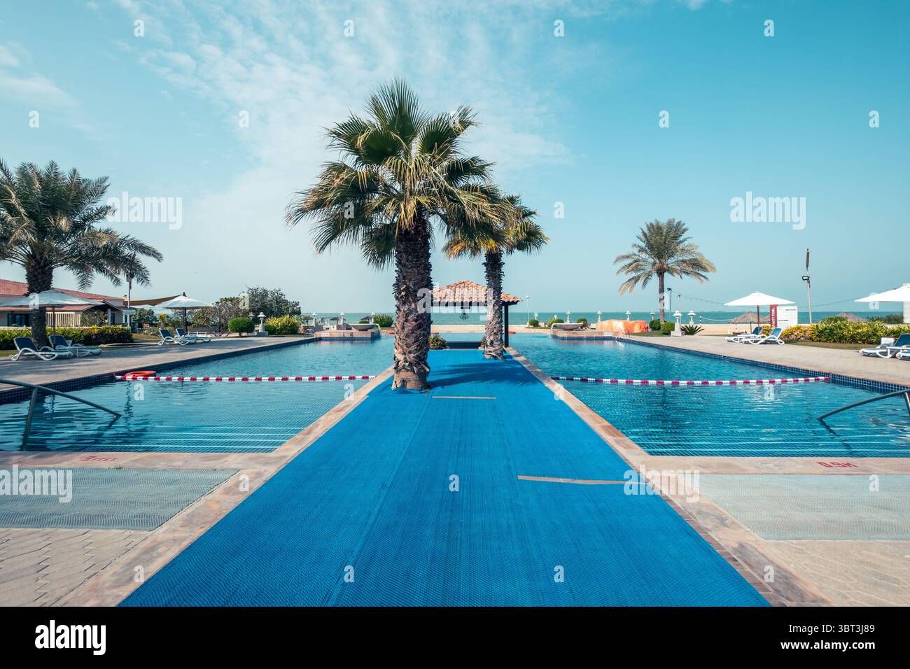Piscina a sfioro nel resort con palme, vacanze tropicali, Bali, rifugio con piscina alle Maldive Foto Stock