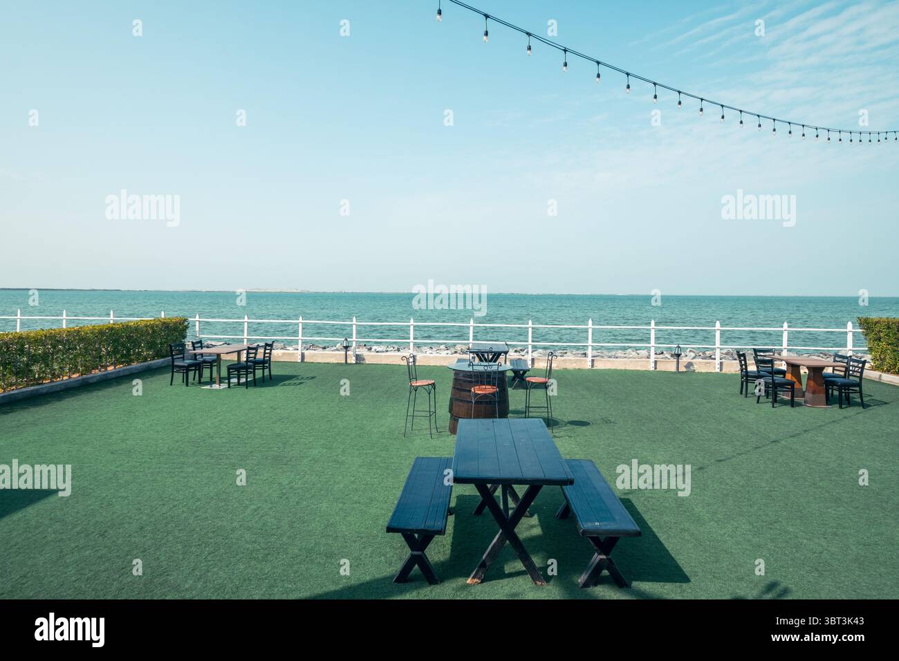 Ristorante con vista panoramica sulla spiaggia, ristorante all'aperto sulla spiaggia in una piacevole giornata di sole, con un'estetica spiaggia sullo sfondo Foto Stock