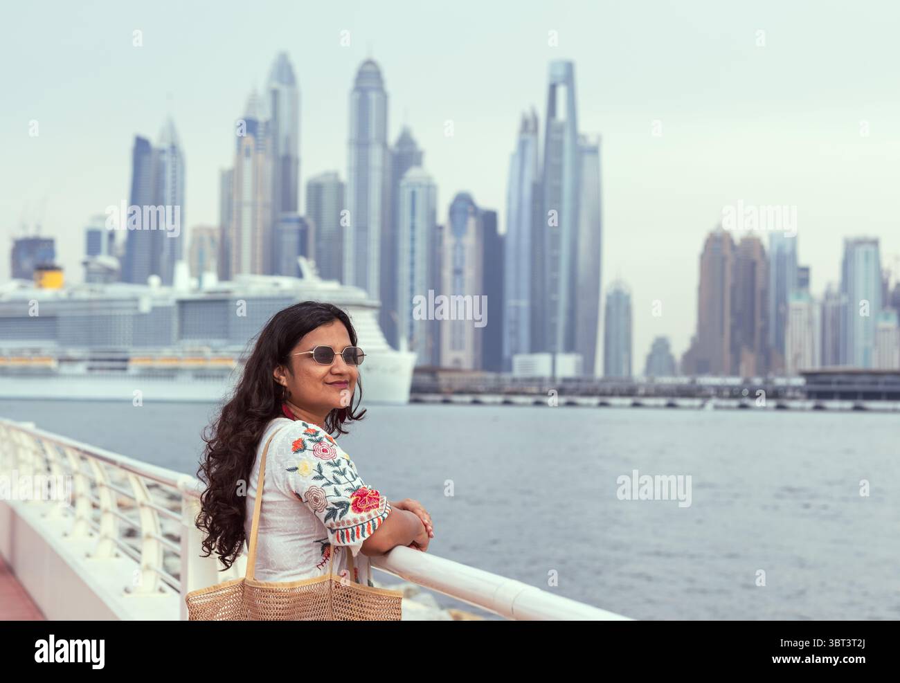 Giovane donna sul ponte con sfondo urbano al tramonto, donna viaggiatrice solitaria foto stock Foto Stock