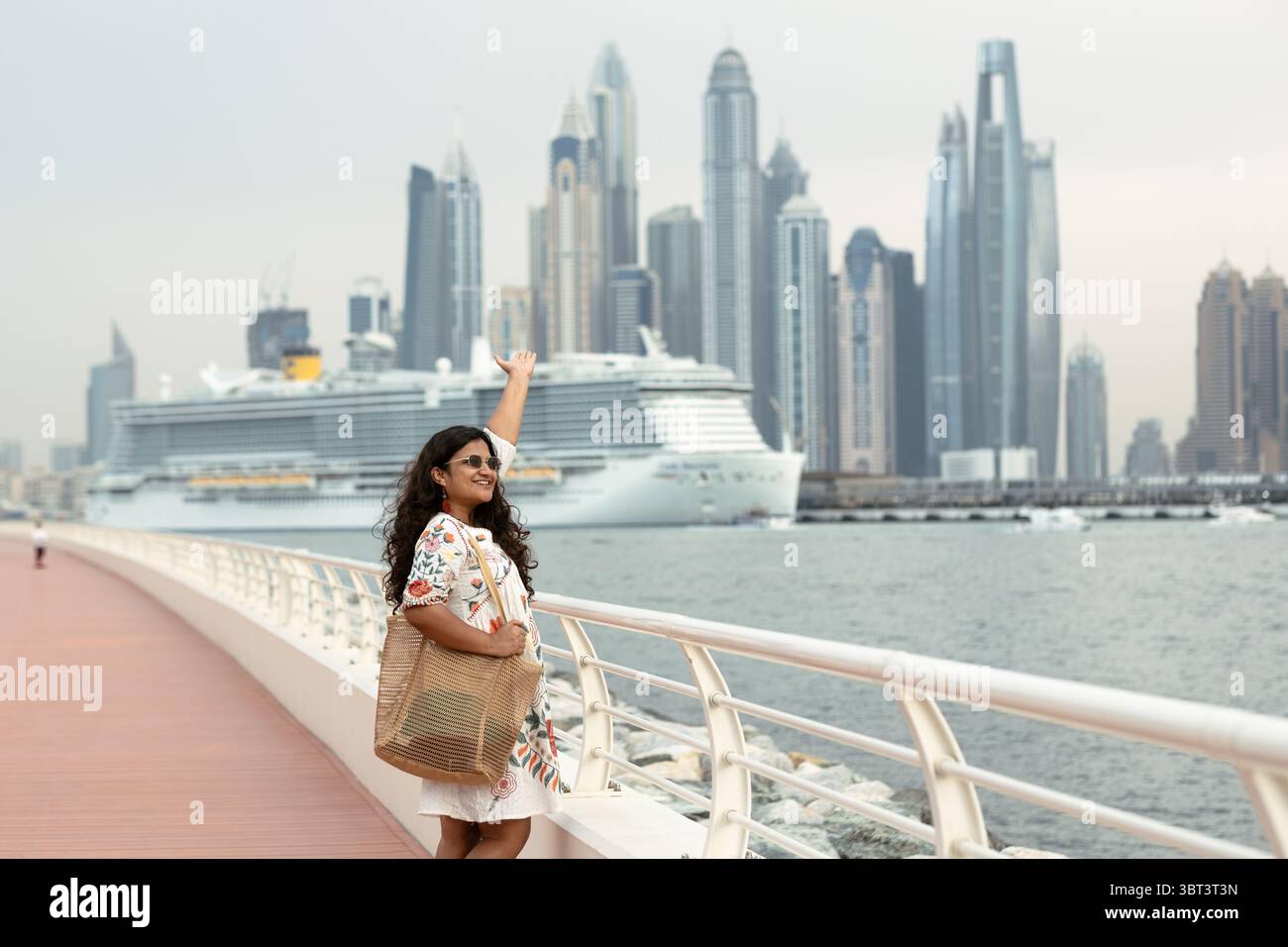 Turista donna che si gode la vista dello skyline di Dubai Marina con crociera sullo sfondo, solo viaggio economico a Dubai Foto Stock