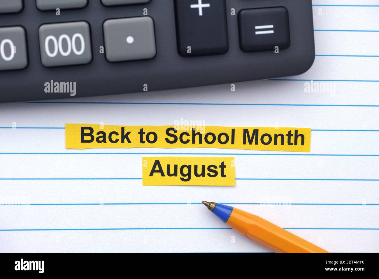 Strisce gialle di carta con le parole Back to School Month - August scritte su di esse in un taccuino aperto vicino a una calcolatrice e a una penna a sfera. Chiudi Foto Stock
