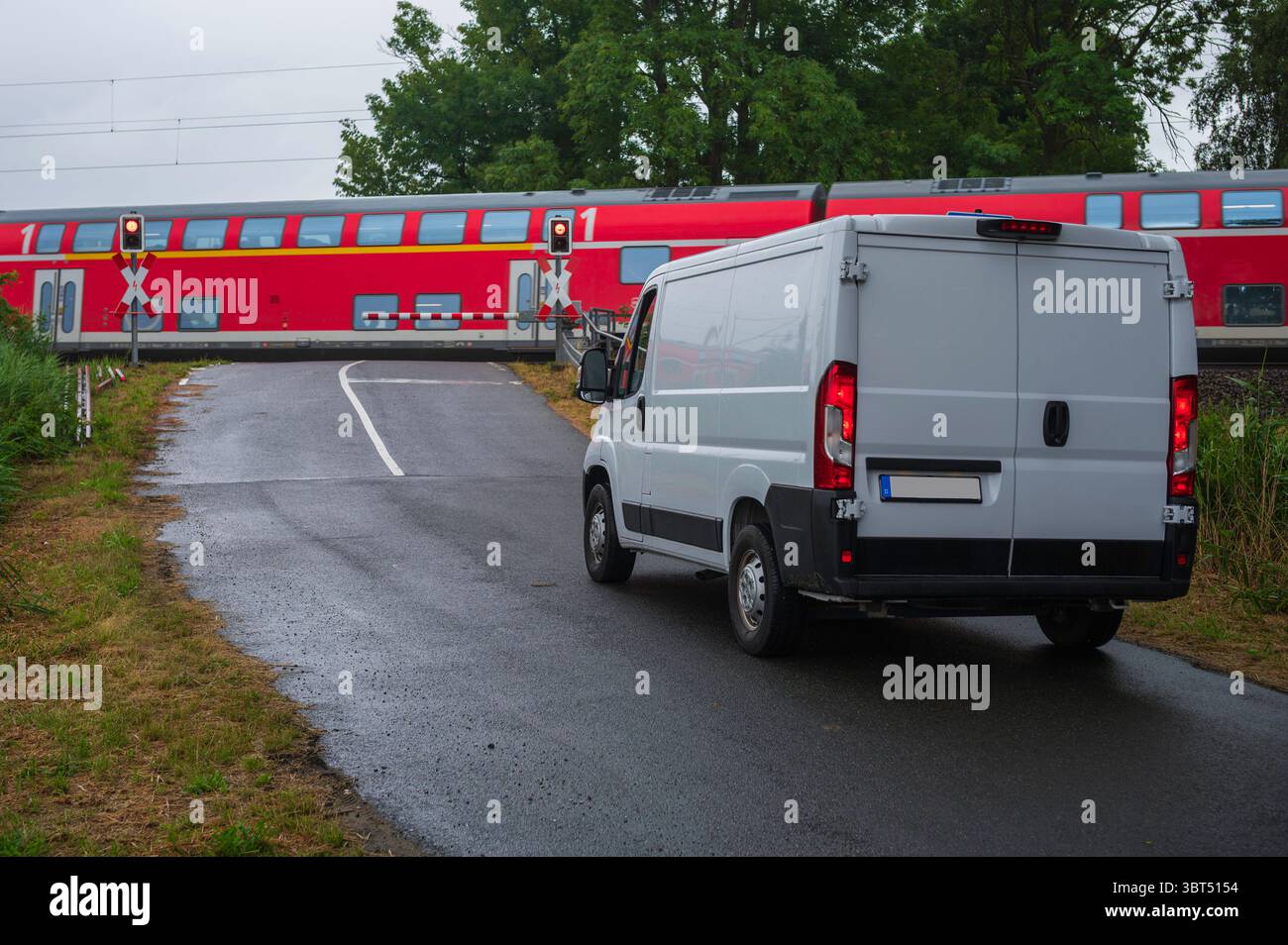 Un furgone ad un passaggio ferroviario Foto Stock