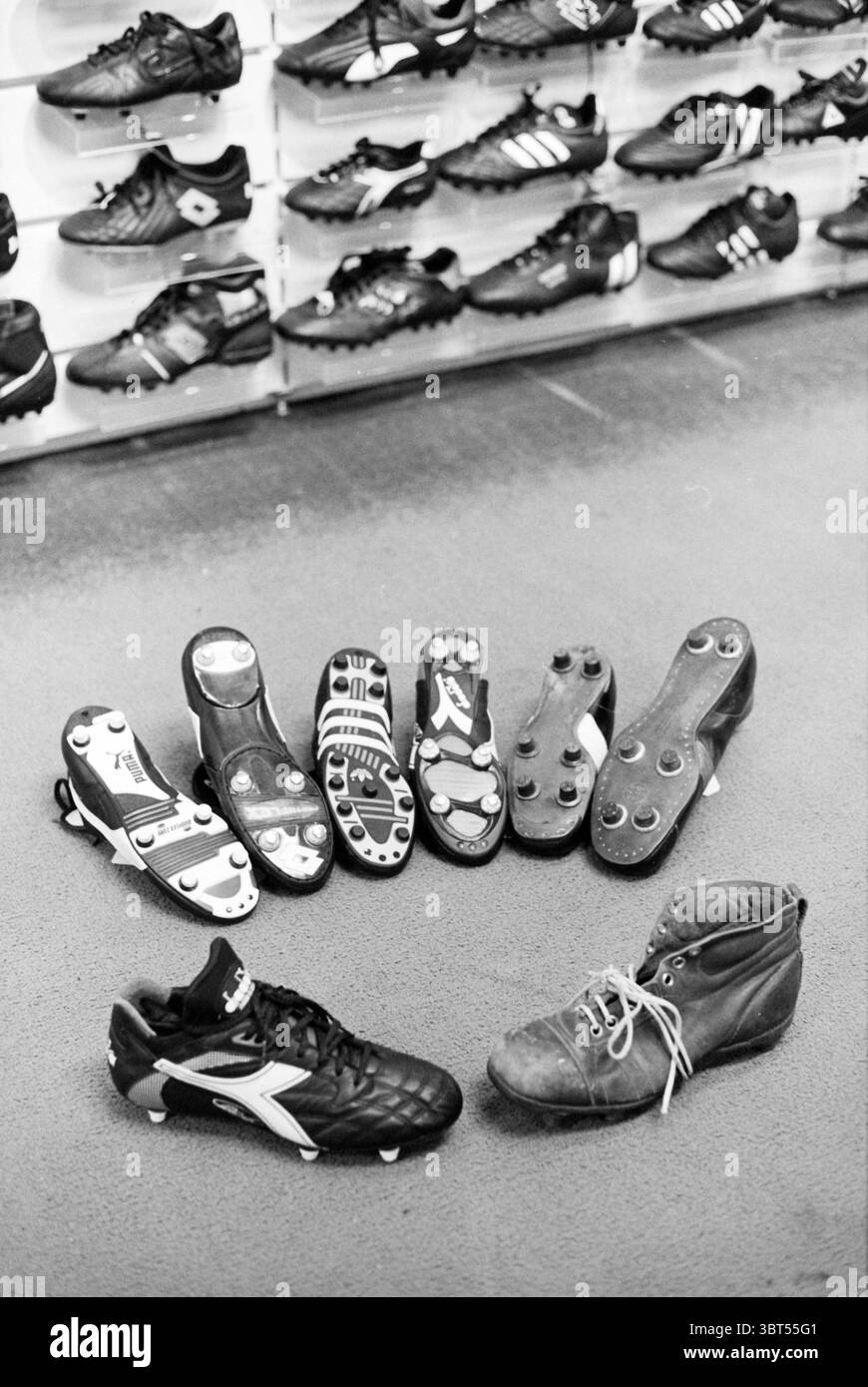 Scarpe da calcio, Whizgle News, Dutch Desk, Paesi Bassi, 1950 - 2000 il 16-08-1993. Questi argomenti sono mostrati nell'immagine. La scena presenta una collezione di varie calzature, incentrate principalmente sulle scarpe da calcio. Sparsi su un pavimento testurizzato ci sono diverse coppie di tacchetti neri, che mostrano stili e design diversi. Le calzature sembrano avere livelli di usura variabili, alcune sembrano nuove di zecca, mentre altre mostrano segni di utilizzo. Tra le scarpe da calcio, c'è una coppia distinta che si distingue per i suoi colori vivaci, forse accentuati da sfumature bianche o rosse, in contrasto con la preda Foto Stock Scarpe da calcio, Whizgle News, Dutch Desk, Paesi Bassi, 1950 - 2000 il 16-08-1993. Questi argomenti sono mostrati nell'immagine. La scena presenta una collezione di varie calzature, incentrate principalmente sulle scarpe da calcio. Sparsi su un pavimento testurizzato ci sono diverse coppie di tacchetti neri, che mostrano stili e design diversi. Le calzature sembrano avere livelli di usura variabili, alcune sembrano nuove di zecca, mentre altre mostrano segni di utilizzo. Tra le scarpe da calcio, c'è una coppia distinta che si distingue per i suoi colori vivaci, forse accentuati da sfumature bianche o rosse, in contrasto con la preda Foto Stock