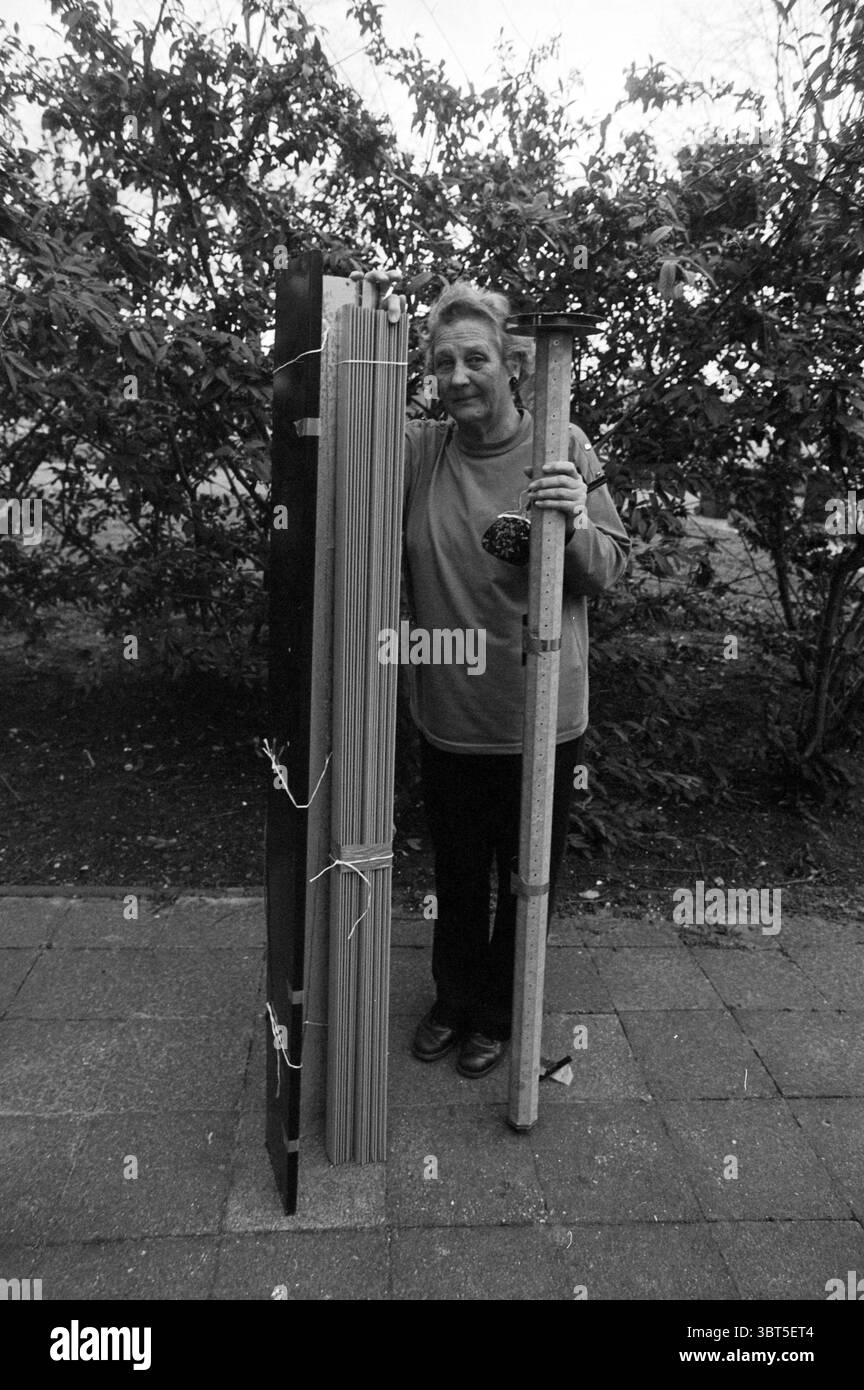 Bacheca a serranda, Whizgle News, Dutch Desk, Paesi Bassi, 1950 - 2000 su 15-11-1994. Questi sono gli elementi dell'immagine. In una scena silenziosa e monocromatica, una donna sta in piedi in modo prominente, la sua espressione è calda e accogliente. È posizionata accanto a due oggetti verticali: Uno è una pila di materiali sottili e allungati strettamente legati tra loro, mentre l'altro assomiglia a uno strumento di misurazione alto, possibilmente un righello o un calibro, suggerendo un collegamento con l'artigianato o la costruzione. La donna indossa una camicia confortevole e la sua postura trasmette un senso di orgoglio e connessione con gli oggetti che si presentano Foto Stock Bacheca a serranda, Whizgle News, Dutch Desk, Paesi Bassi, 1950 - 2000 su 15-11-1994. Questi sono gli elementi dell'immagine. In una scena silenziosa e monocromatica, una donna sta in piedi in modo prominente, la sua espressione è calda e accogliente. È posizionata accanto a due oggetti verticali: Uno è una pila di materiali sottili e allungati strettamente legati tra loro, mentre l'altro assomiglia a uno strumento di misurazione alto, possibilmente un righello o un calibro, suggerendo un collegamento con l'artigianato o la costruzione. La donna indossa una camicia confortevole e la sua postura trasmette un senso di orgoglio e connessione con gli oggetti che si presentano Foto Stock