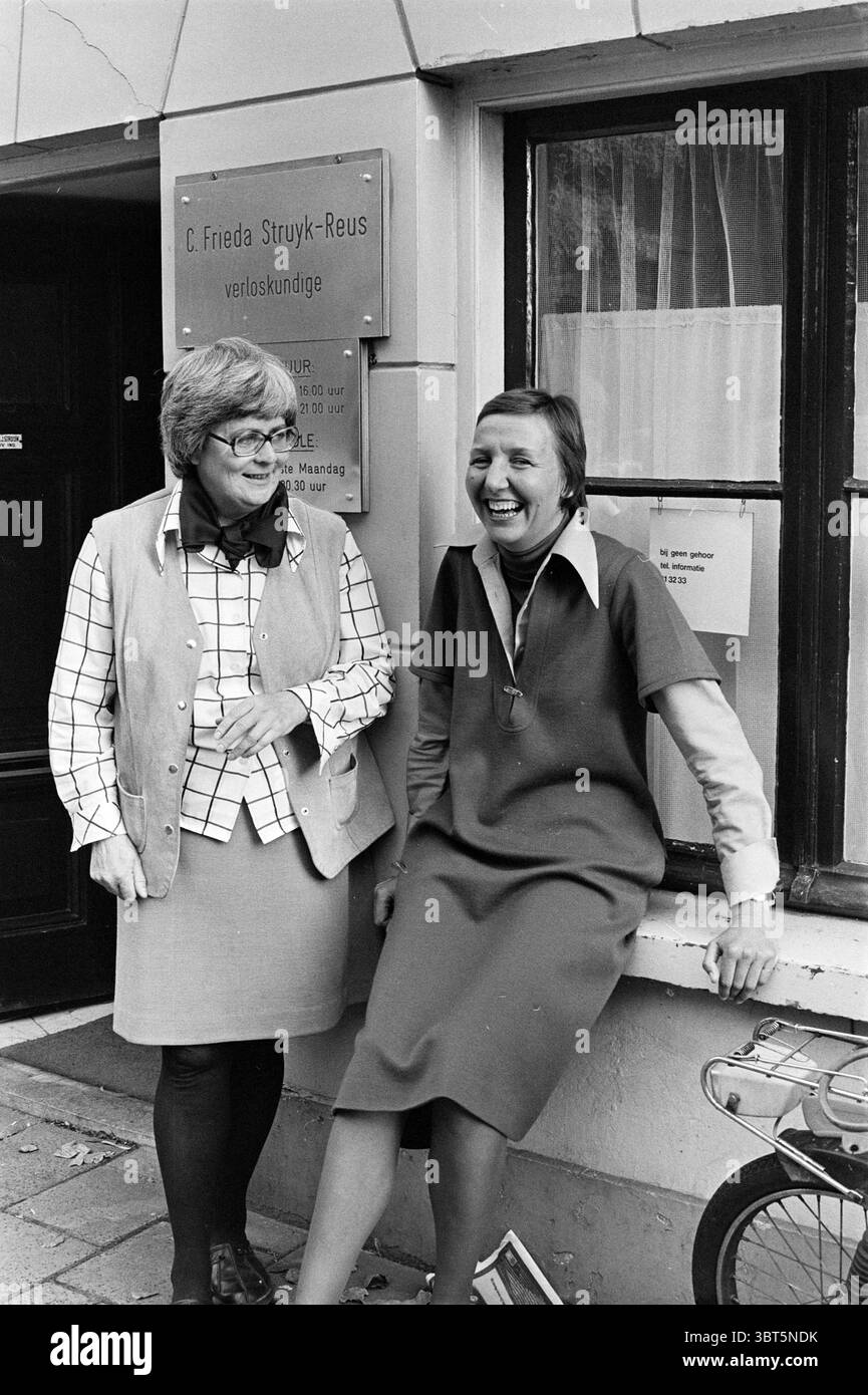 2 ostetriche Haarlem Medicina metodo di guarigione persone Haarlem Staten Bolwerk Paesi Bassi, Whizgle News, Dutch Desk, Paesi Bassi, 1950 - 2000 il 29-09-1975. L'immagine mostra questi argomenti. In questa scena, due donne stanno fuori da un edificio che presenta una grande finestra con un filtraggio della luce attraverso le tende. L'esterno dell'edificio e' di un tono neutrale, possibilmente grigio o beige, contribuendo ad una classica estetica urbana. Una donna, a sinistra, ha i capelli corti e in stile e indossa grandi occhiali rotondi che aggiungono al suo aspetto intellettuale. Indossa un giubbotto leggero su una camicia a scacchi, com Foto Stock