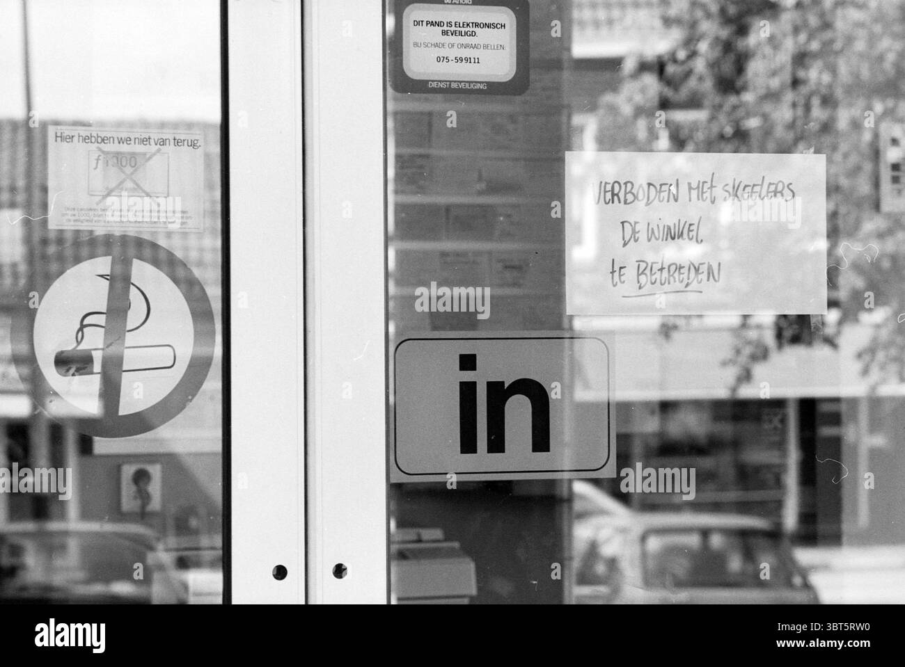 Pattini in linea proibiti, Whizgle News, Dutch Desk, Paesi Bassi, 1950 - 2000 il 07-08-1995. Questi argomenti sono mostrati nell'immagine. Nella scena, è presente una porta, incorniciata da una struttura in vetro. L'ingresso ha un riflesso evidente dell'ambiente circostante, suggerendo l'attività oltre, anche se l'attenzione è sull'area circostante. Il pavimento è piastrellato, suggerendo un ambiente pubblico o aziendale. A sinistra, un segno circolare, con un suggestivo bordo rosso, indica un divieto, probabilmente legato al fumo, come dimostra un'icona prominente che lo simboleggia. Sotto c'è un recta Foto Stock