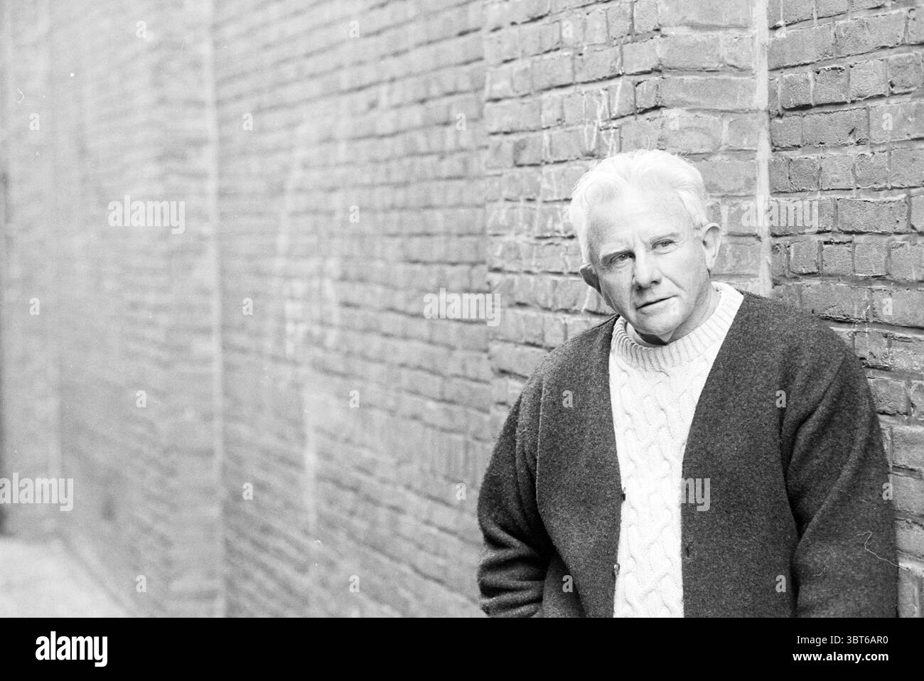 John Pintauro Haarlem Theater, Whizgle News, Dutch Desk, Paesi Bassi, 1950 - 2000 il 14-04-1996. L'immagine include questi argomenti. Nella scena, un uomo con un'espressione premurosa si trova contro un muro di mattoni testurizzati che si estende sullo sfondo. I mattoni sono invecchiati, con un aspetto resistente agli agenti atmosferici e segni di sottile scolorimento, creando un senso di storia e profondità. I capelli di colore chiaro dell'uomo contrastano con le tonalità più scure della parete e il suo maglione di lana, caratterizzato da un motivo a filo, aggiunge un tocco di calore e intimità all'atmosfera generale. La sua posa è rilassata Foto Stock