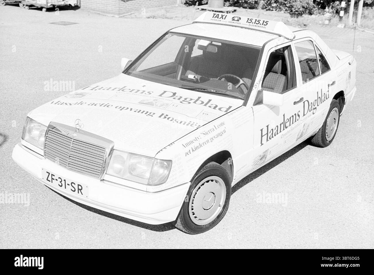 Pubblicità HD su taxi, Whizgle News, Dutch Desk, Paesi Bassi, 1950 - 2000 il 31-08-1993. L'immagine contiene questi argomenti. La scena presenta una classica berlina in primo piano, principalmente in bianco e nero. La carrozzeria elegante e lucida del veicolo riflette delicatamente la luce, offrendo una qualità senza tempo. La sua superficie superiore è adornata da un distintivo cartello taxi, che suggerisce il suo ruolo di mezzo di trasporto. Il design della vettura è caratterizzato da curve morbide e linee nitide che ne accentuano l'eleganza. La griglia anteriore è audace e ospita il simbolo che indica il suo marchio. Le ruote, leggermente girate, gli danno un Foto Stock