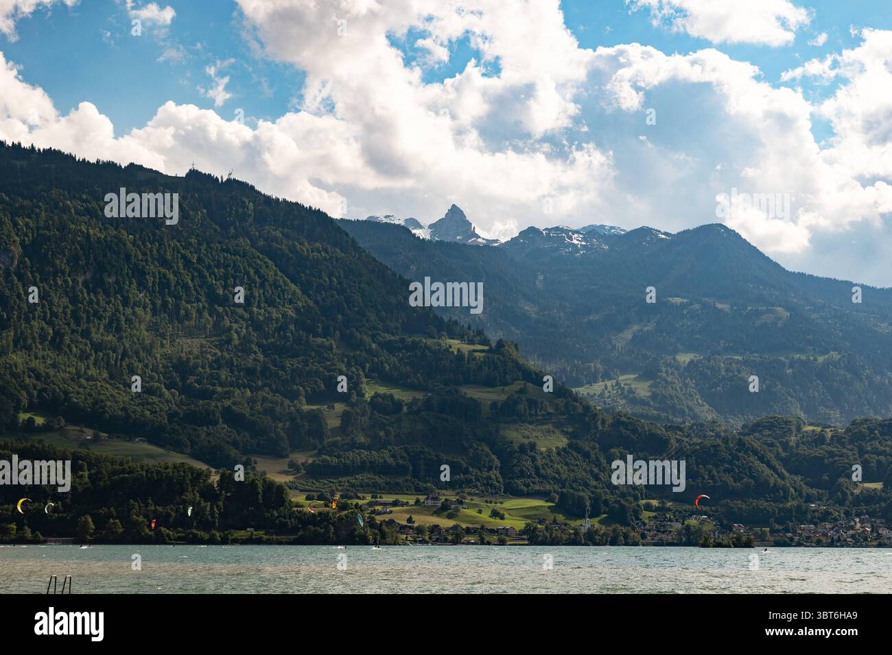 Vista dal lago Walen alla vetta di Gufelstock, Magerrain, Svizzera, Canton San Gallo, Alpi svizzere. Vista dal lago Walen alla vetta di Gufelstock, Magerrain, Svizzera, Canton San Gallo, Alpi svizzere. Kite surfer sul lago, sole, nuvole, catena montuosa. Vacanze, sport, attività ricreative, turismo, destinazione di viaggio, attività ricreative. svizzera B97A8424 Foto Stock