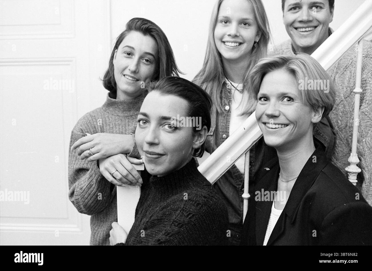 Models 'People' H'lem Haarlem Paesi Bassi, Whizgle News, Dutch Desk, Paesi Bassi, 1950 - 2000 il 28-12-1994. L'immagine include questi argomenti. La scena presenta un gruppo di cinque persone, posizionate su una scala che funge da sfondo. L'ambiente è luminoso e arioso, impreziosito da una luce naturale che entra da una finestra appena fuori dalla vista. Una parete di colore neutro completa l'atmosfera morbida e serena. Il gruppo ha un aspetto diverso, con diverse acconciature ed espressioni che trasmettono un senso di cameratismo e gioia. 1. La figura centrale anteriore ha un sorriso accattivante, il loro li Foto Stock
